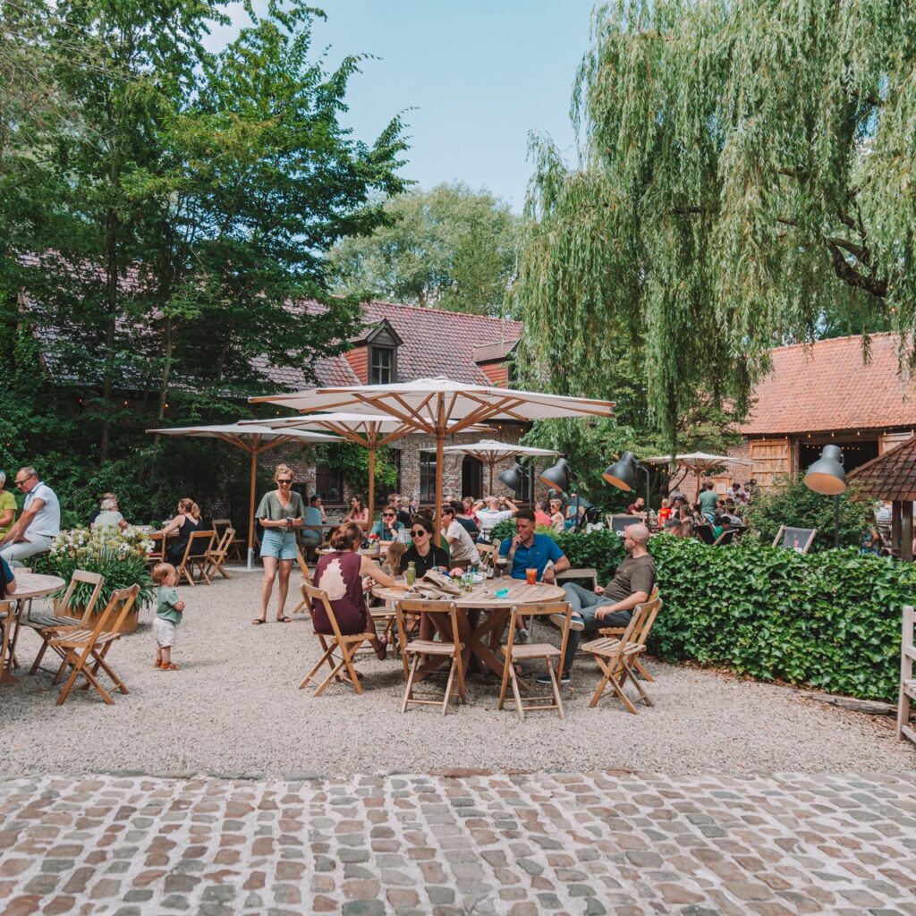 Sfeerbeeld van Bar Botaniek met mensen aan een tafel onder een parasol