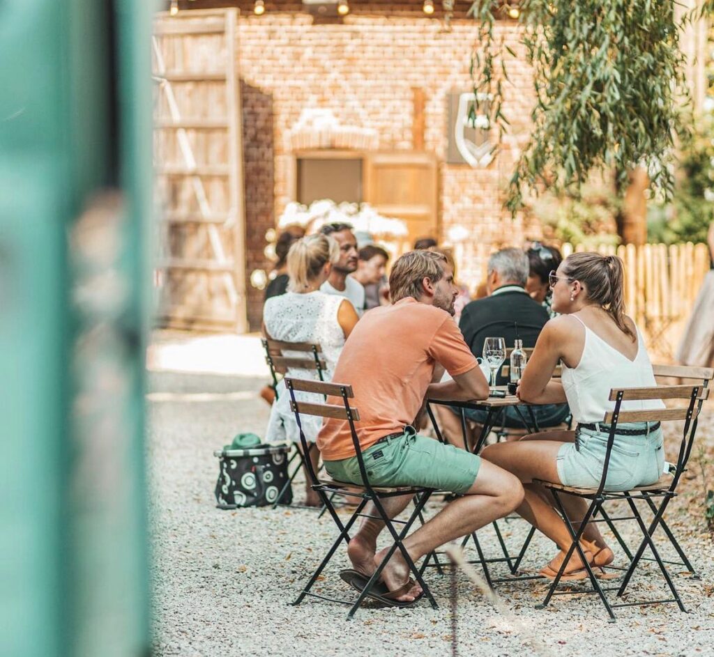 Koppel geniet van de zon aan een tafeltje in Bar Botaniek